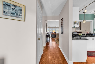 Corridor featuring a textured ceiling, a sink, bas