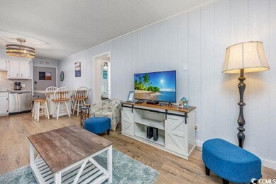 Living area featuring light wood-type flooring and a textured ceiling