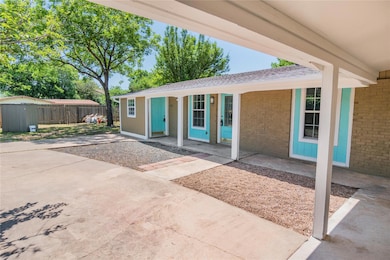 Entrance to property featuring brick siding and a shingled roof