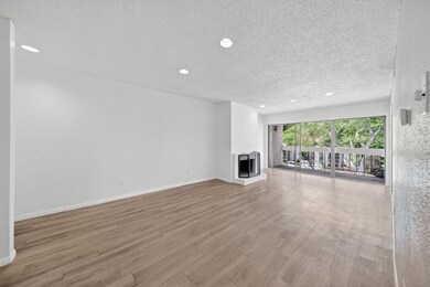 Spacious living room with balcony and cozy brick f