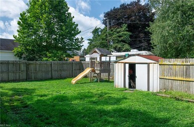 View of yard featuring a storage shed and a playgr