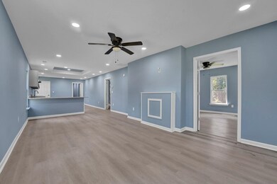 Unfurnished living room featuring sink, light wood
