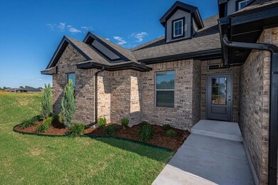 Doorway to property with a yard, brick siding, and a shingled roof