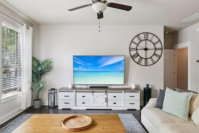 Living area with dark wood finished floors and a ceiling fan