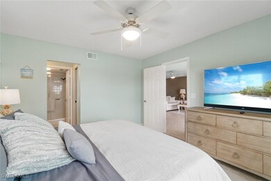 Bedroom with a ceiling fan, ensuite bath, and visi
