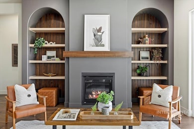 Living room featuring built in features, wood finished floors, and a glass covered fireplace