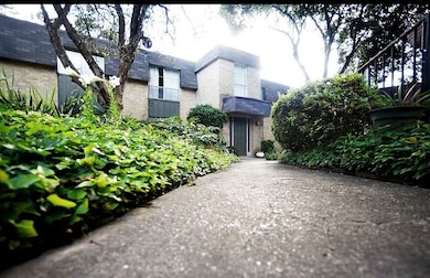 View of front of building featuring brick siding and mansard roof