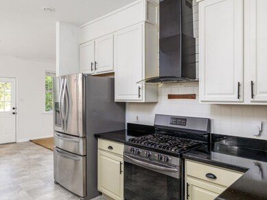 Kitchen with stainless steel appliances, wall chi