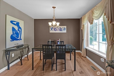 Formal Dining Room. New Maple flooring. Picture windows overlooks large level play area.