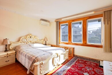 Bedroom with wood finished floors and a wall mounted AC
