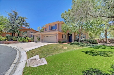 View of front of house with a front yard, concrete driveway, stucco siding, and a garage