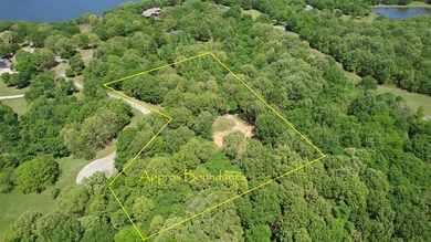 Drone / aerial view with a wooded view and a water view