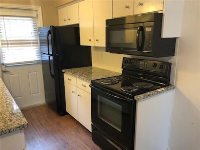 Kitchen featuring black appliances, dark wood fini