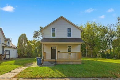 View of front of house featuring a front yard, covered porch, and roof with shingles