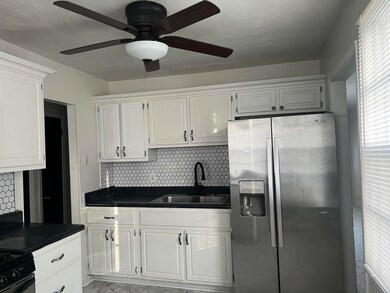 Kitchen with white cabinets, stainless steel fridg