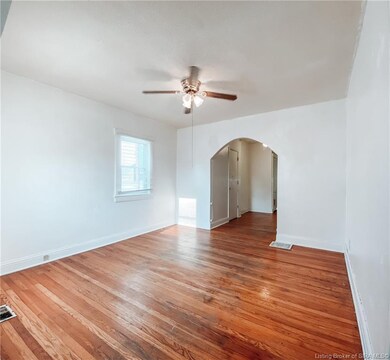 Living room with original hardwood floors and arch