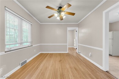 Unfurnished room with crown molding, ceiling fan, and light hardwood / wood-style floors