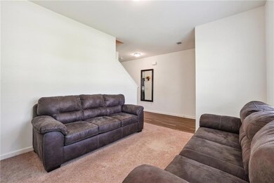 Carpeted living area featuring baseboards