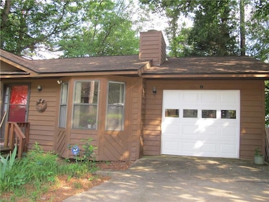 Ranch-style house with a chimney, a garage, roof w
