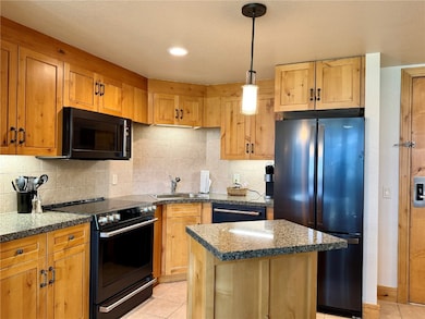 The kitchen has a refrigerator, oven, microwave, a