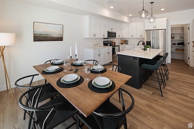 Dining room with light wood-type flooring and recessed lighting