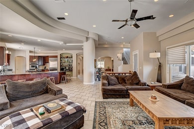 Living area with arched walkways, a ceiling fan, r