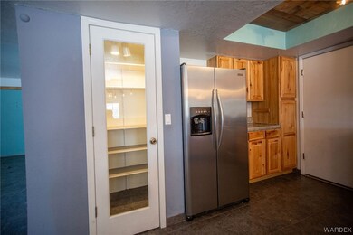 Kitchen with dark tile floors, stainless steel ref