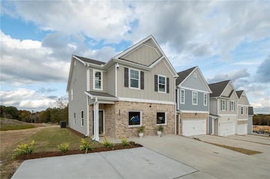 Craftsman inspired home featuring driveway, board and batten siding, brick siding, and an attached garage