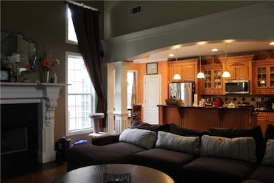 Living room with arched walkways, dark wood finish