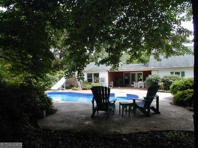 Swimming Pool/Hot Tub/Sauna. Kidney shaped pool with a slide viewed from a shady retreat towards the covered patio off of the great room.
