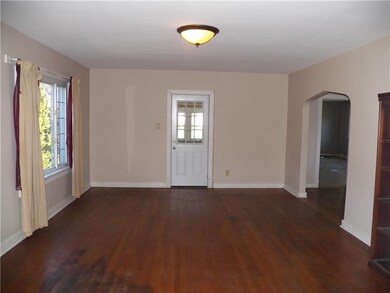 Spacious living room features original hardwood fl