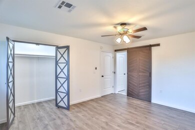 Unfurnished bedroom featuring a barn door, a close