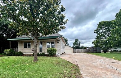 View of front entrance to elongated, widened parking area, detached garage & fenced storage!