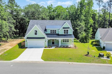 View of front of property featuring concrete driveway, covered porch, a standing seam roof, metal roof, and a front yard
