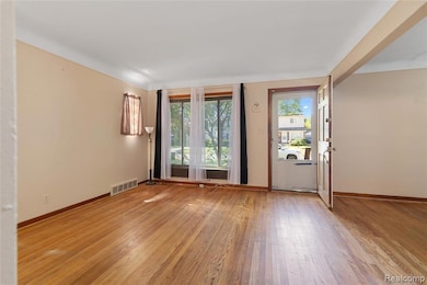Spare room featuring light wood-style flooring and baseboards
