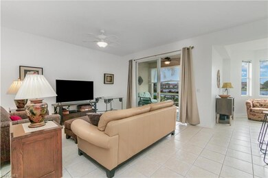 Living room with ceiling fan, light tile patterned floors, and baseboards