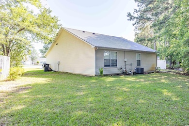 Rear view of house with metal roof, a yard, and ce