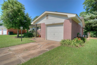 Ranch-style house featuring driveway, a front lawn, and brick siding