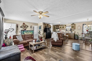 Living room with ceiling fan with notable chandeli