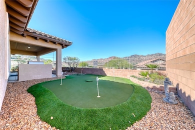 Fenced backyard with a putting area, a patio, and a mountain view