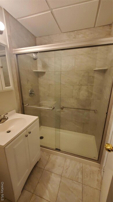 Bathroom featuring vanity, a stall shower, and light tile patterned flooring