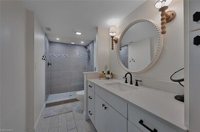 Bathroom featuring vanity, toilet, and tiled showe