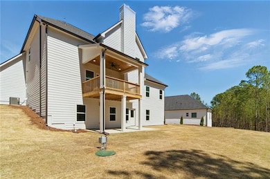 Back of property with a ceiling fan, a chimney, a 