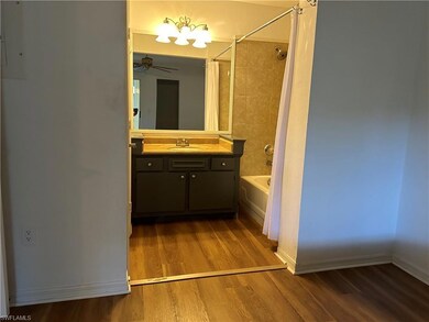 Bathroom featuring vanity, ceiling fan, hardwood / wood-style flooring, and tiled shower / bath combo