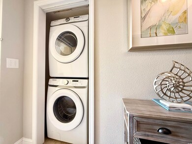 Clothes washing area featuring stacked washer and 