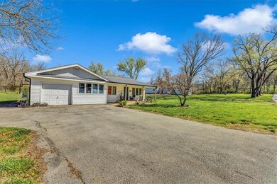 Ranch-style home featuring a front lawn and a garage
