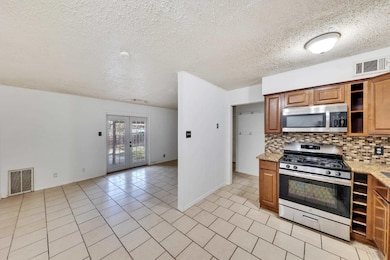 Kitchen featuring stainless steel appliances, bac