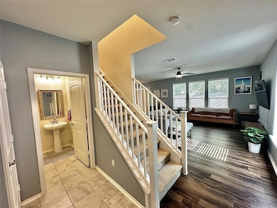 Staircase with wood finished floors and a ceiling fan