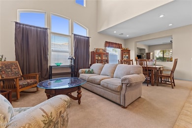 Living room featuring ceiling fan, light carpet, a