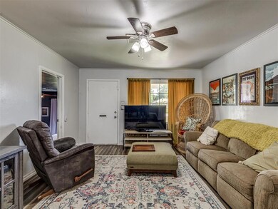 Living room featuring crown molding, ceiling fan, 
